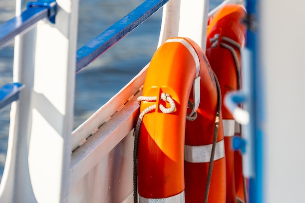 Aro salvavidas de primer plano en un barco. Aro salvavidas rojo en la baranda del barco con la superficie del mar