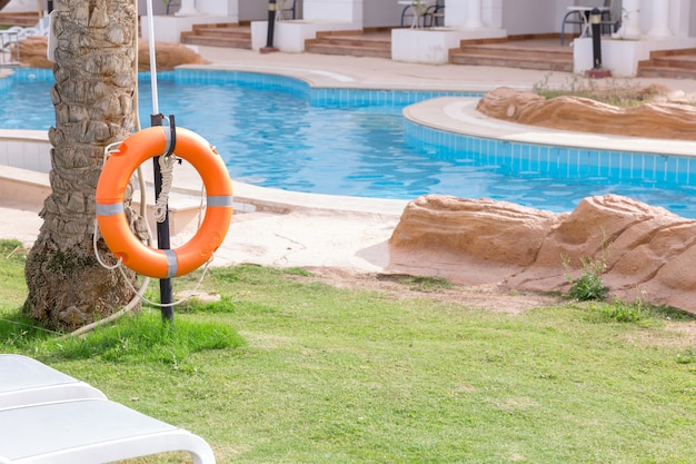 Aro salvavidas en la valla, junto a la piscina de vacaciones en el hotel