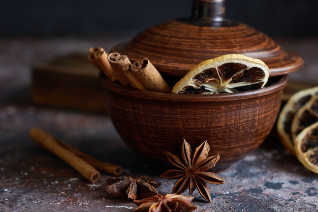 Aroma quente com vinho: canela, anis estrelado, casca de laranja em uma tigela marrom