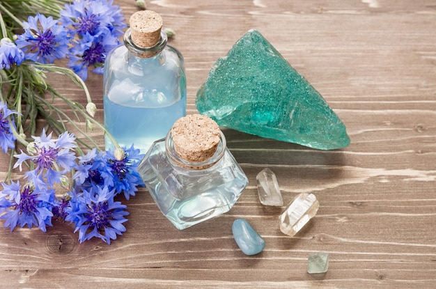 Foto aromaterapia o concepto cosmético agua de flor de aciano en botella de vidrio y piedra mineral natural