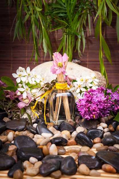 Aromaterapia, spa, tratamientos de belleza y bienestar con piedra de masaje, flores, frasco