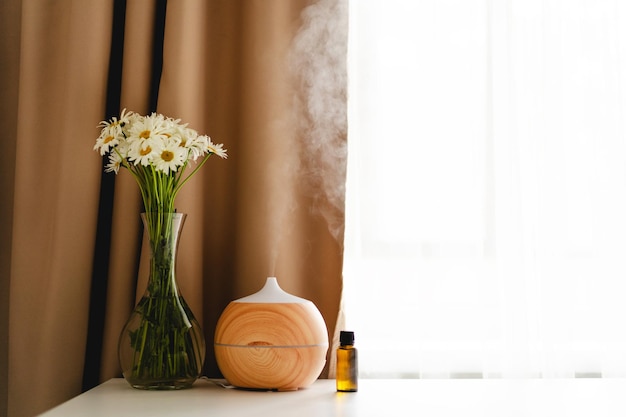 Aromatherapie-Konzept Aromaöl-Diffusor auf dem Tisch gegen das Fenster Lufterfrischer Ultraschall-Aroma-Diffusor für zu Hause