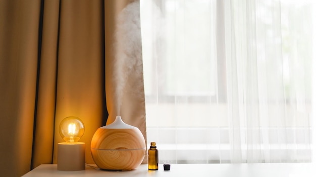 Aromatherapie-Konzept Aromaöl-Diffusor auf dem Tisch gegen das Fenster Lufterfrischer Ultraschall-Aroma-Diffusor für zu Hause