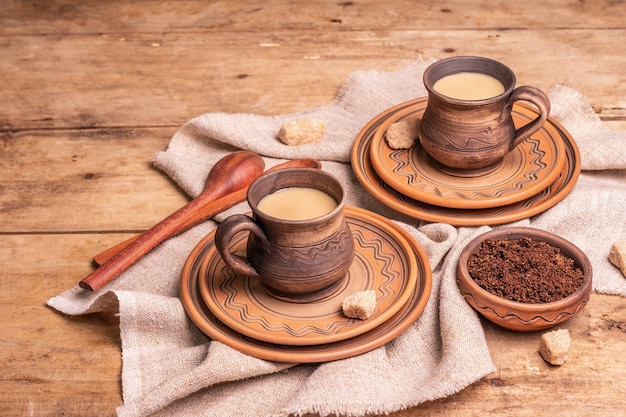 Aromatischer Kaffee im gemütlichen Wohnstil. Keramikbecher, Heißgetränk, Holztisch. Morgen, gute Laune, Platz kopieren