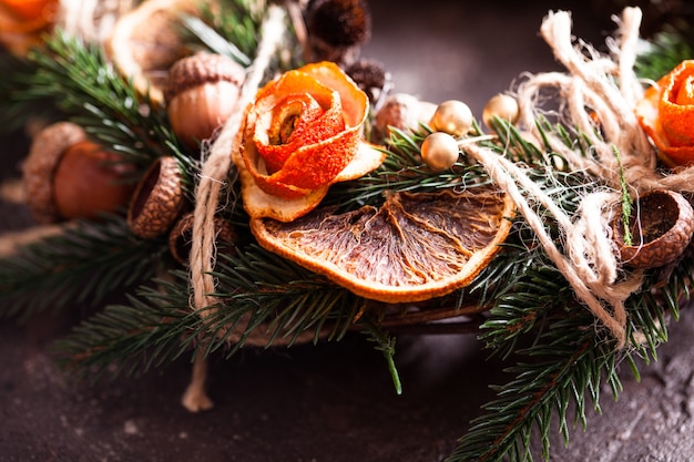 Aromatischer Öko-Weihnachtskranz mit trockenen Orangen- und Anissternen, verzierten Mandarinenschalenrosen, Nahaufnahmedetails