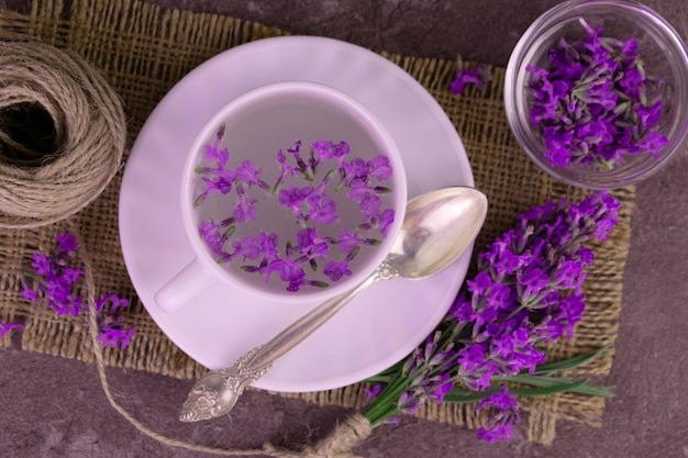 Aromatischer Lavendeltee in einer Tasse ein Strauß frischer Lavendelblüten. Flach liegen.