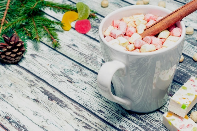 Foto aromatisches kakaogetränk mit marshmallow und zimtstange auf hölzernem hintergrund weihnachtstanne