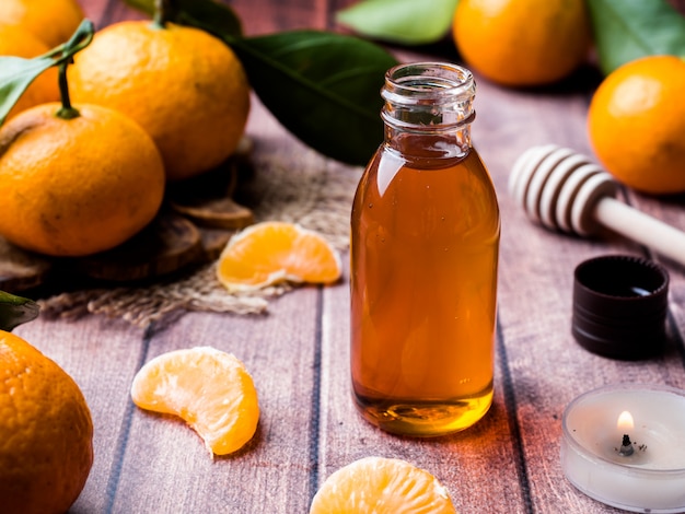 Aromatisches Mandarinenöl, mit Mandarinen auf einer Holzoberfläche