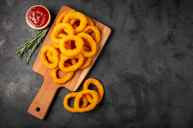 Aros de cebolla crujientes con salsa de tomate.