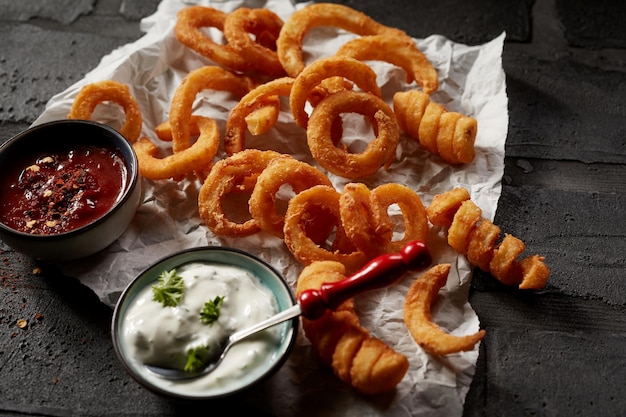 Aros de cebolla y papas fritas con salsas