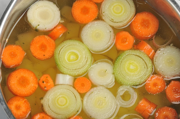 Aros de cebolla y rodajas de zanahoria en una cacerola