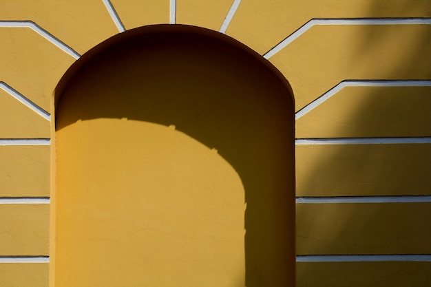 Arqueado de janela no edifício antigo amarelo com sombra