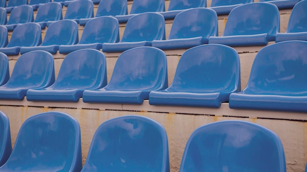 Arquibancada vazia no estádio esportivo Assentos azuis no estádio de rua Fechar