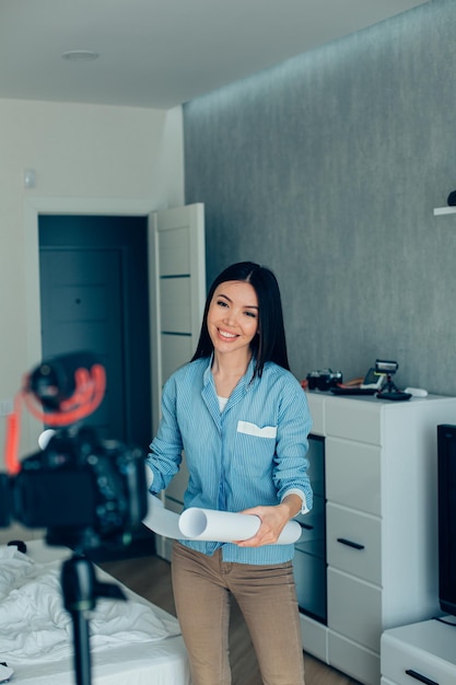 Arquitecta alegre grabando un nuevo video sobre su proyecto mientras estaba en casa en el dormitorio