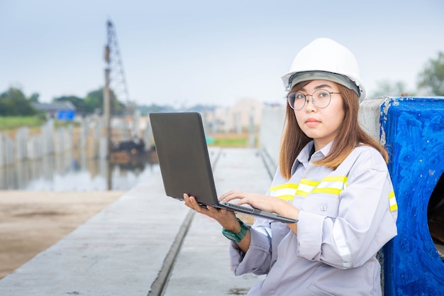 Una arquitecta líder que trabaja con una computadora portátil en el sitio de construcción o sitio de construcción