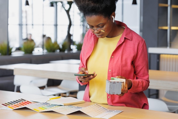 La arquitecta o diseñadora afroamericana trabaja en una oficina de coworking, una mujer crea un