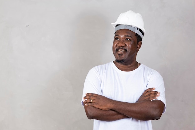 Arquitecto afro hombre vestido con casco de constructor sobre fondo aislado con feliz sonrisa fresca en la cara con espacio de copia