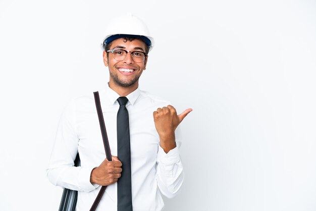 Arquitecto brasileño con casco y sosteniendo planos apuntando hacia un lado para presentar un producto