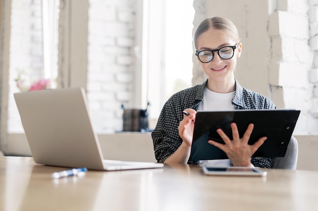 El arquitecto desarrollador es una joven empleada de la empresa que trabaja en la oficina con documentos