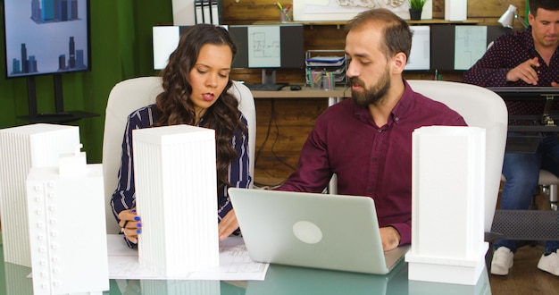 Arquitecto y diseñador trabajando en planos en agencia de medios creativos.