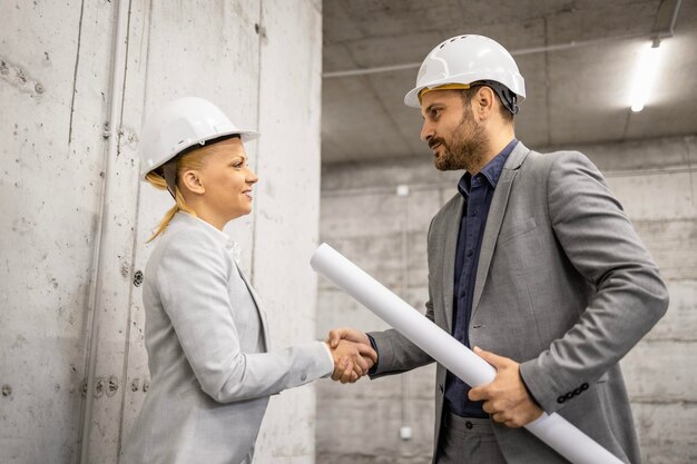 Arquitecto estrechando la mano con el ingeniero de construcción para una cooperación exitosa