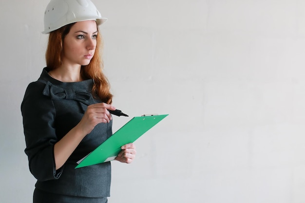 Foto arquitecto femenino en el sitio de construcción con dibujos y un cuaderno