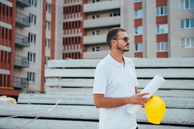 Arquitecto guapo con un casco en el sitio