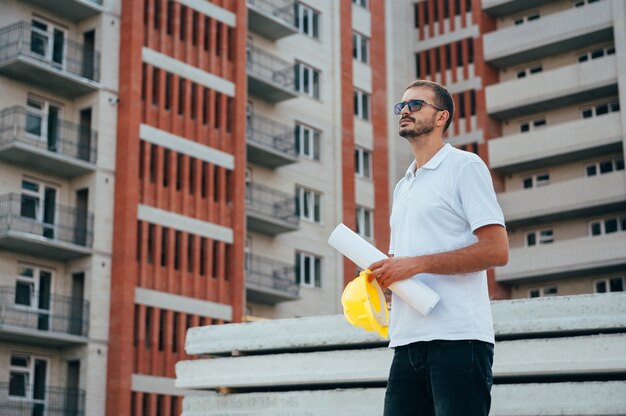 Arquitecto guapo con un casco en el sitio