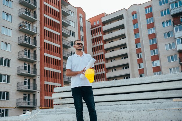 Arquitecto guapo con un casco en el sitio