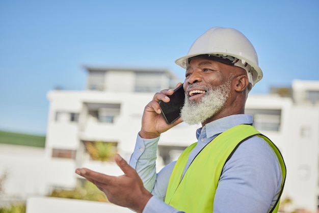Arquitecto de hombre negro y teléfono para la construcción en la ciudad o construcción de conversación y discusión Ingeniero o contratista afroamericano con una sonrisa hablando por teléfono inteligente en arquitectura