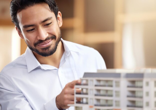 Foto arquitecto hombre y verificar la construcción del modelo de construcción con una sonrisa en la cara y proyecto de arquitectura empresario en diseño de oficinas e ingeniero con empresa de desarrollo inmobiliario y trabajo de construcción