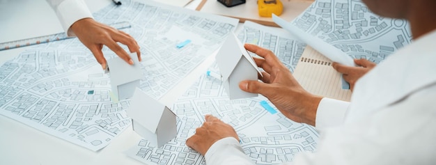 Foto el arquitecto y el ingeniero trabajador trabajan en la planificación oratoria del proyecto de construcción de bienes raíces con cartografía y mapa catastral del área urbana para guiar el plan de negocios del desarrollador de la construcción de la ciudad