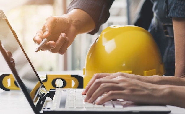 Arquitecto ingeniero trabajando concepto y herramientas de construcción o equipo de seguridad en la mesa.