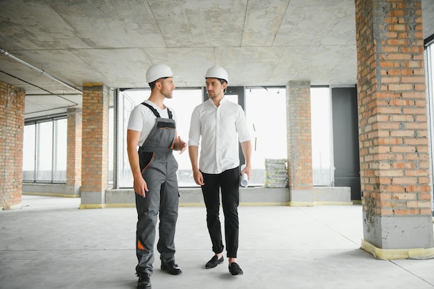 Arquitecto masculino dando instrucciones a su capataz en el sitio de construcción