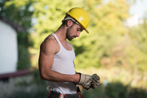 Arquitecto masculino exitoso en un sitio de construcción con guantes despega