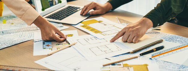 Arquitecto muestra el punto de error en el plan mientras el análisis en la delineación de la computadora portátil