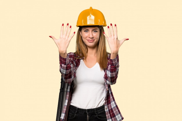 Arquitecto mujer contando diez con los dedos en amarillo