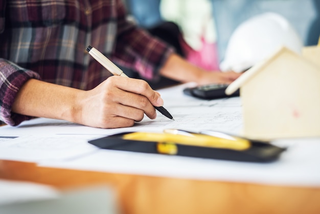 Arquitecto mujer dibujar planos en el lugar de trabajo de oficina.