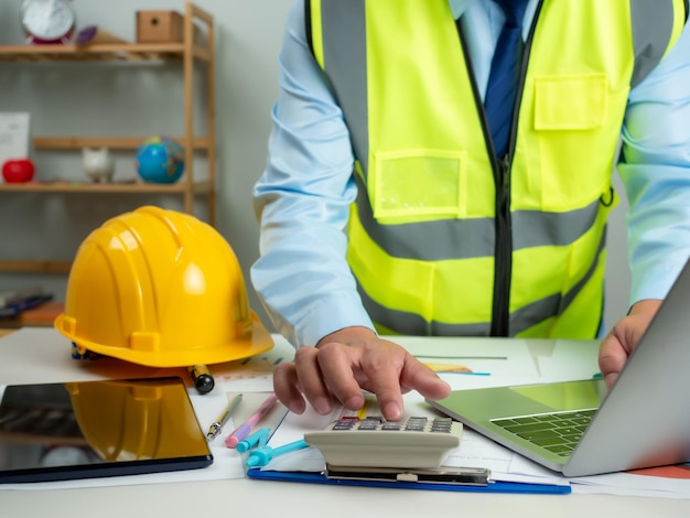 Arquitecto o ingeniero que utiliza la computadora para trabajar en el escritorio Cálculo de costes Planificación de la construcción
