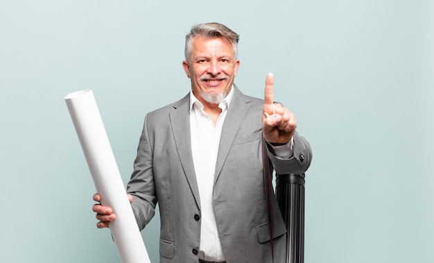 Arquitecto senior sonriendo con orgullo y confianza haciendo la pose número uno triunfalmente, sintiéndose como un líder