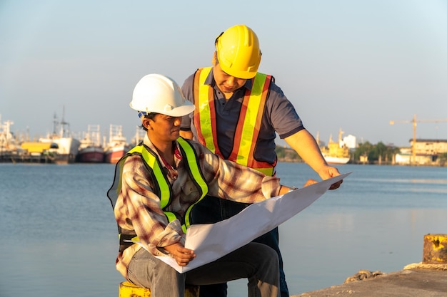 Arquitectos masculinos discutiendo sobre el plano contra el mar