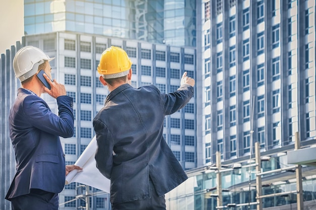 Foto arquitectos masculinos de pie contra edificios modernos en la ciudad