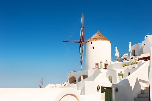 Arquitectura blanca en la isla de Santorini, Grecia. Antiguo molino de viento contra el cielo azul