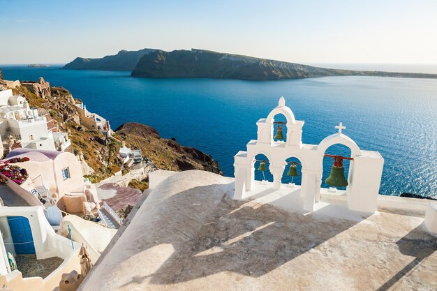 Arquitectura blanca en la isla de Santorini, Grecia. Campanario en la ciudad de Oia. Hermosa vista al mar