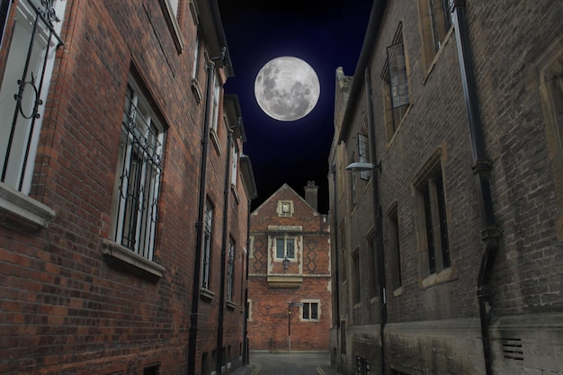 Arquitectura británica Oxford street en una foto oscura con una gran luna llena en el cielo