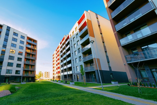 Arquitectura de fachada de casa residencial de apartamentos con instalaciones al aire libre. Cielo azul en el fondo.