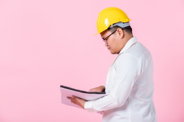 Arquiteto com um capacete de segurança olhando documentos