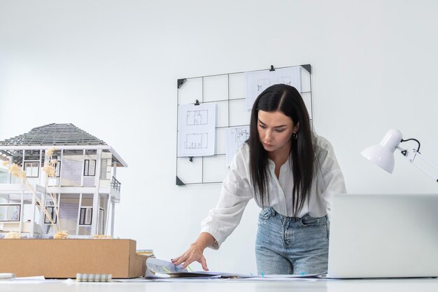 Arquiteto compara a estrutura da casa entre o plano e o laptop imaculado