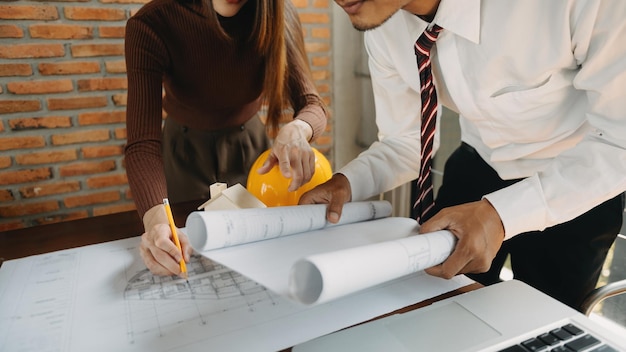 Arquiteto criativo projetando nos grandes desenhos no escritório escuro ou café na luz da manhãxA