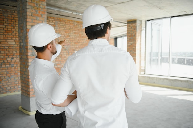 Arquiteto de jovem dois em um canteiro de obras de construção